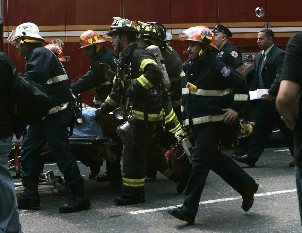 NEW YORK - JULY 10: Firefighters and emergency crews rush a severely injured survivor from a building that exploded and collapsed July 10, 2006 in New York. Fire officials suspect a gas leak in the explosion, which destroyed a four story building. (Photo by Chris Hondros/Getty Images)