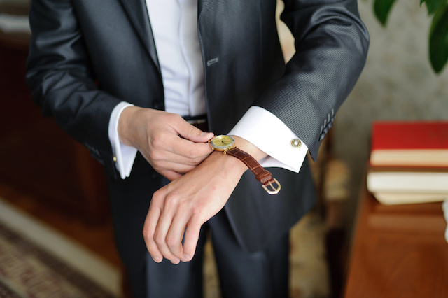 groom clasping stylish watch band on his wrist