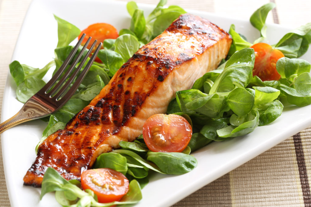 Grilled salmon with a honey glaze on a bed of lambs lettuce